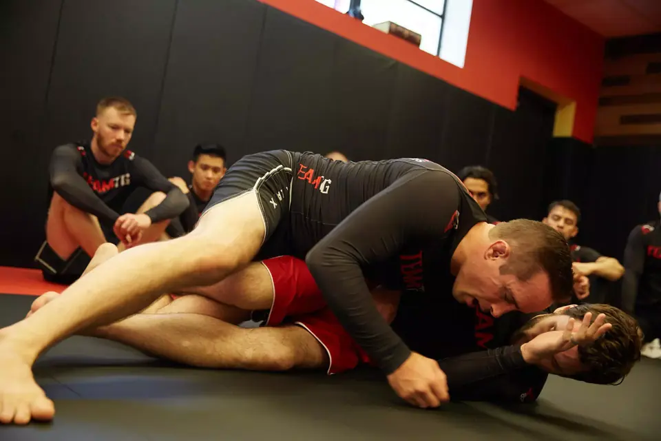 Adult students practice no-gi Brazilian Jiu-Jitsu during class