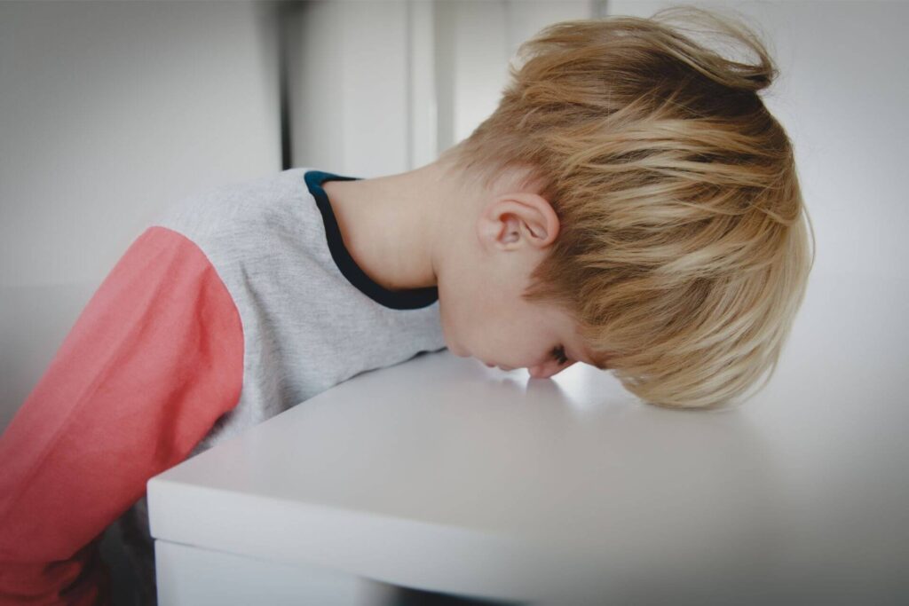 Stressed kid face down on the table reason why kids need martial arts training in today's world