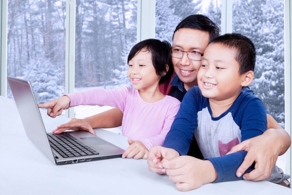 Two kids interested in martial arts watching movie with dad